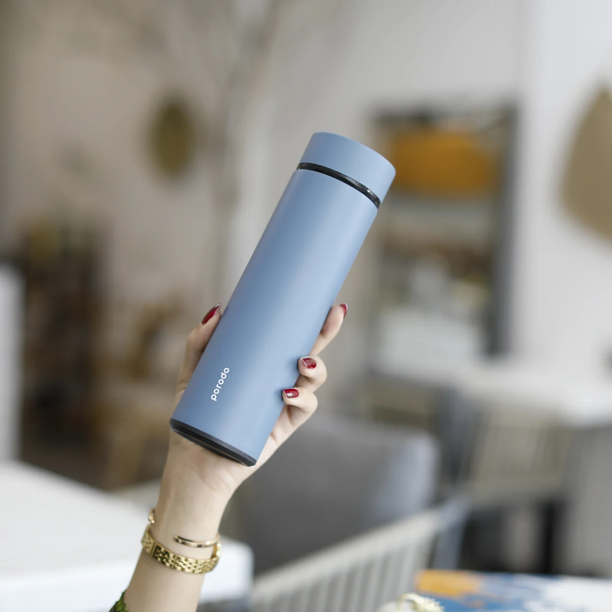 Blue Porodo bottle held in hand