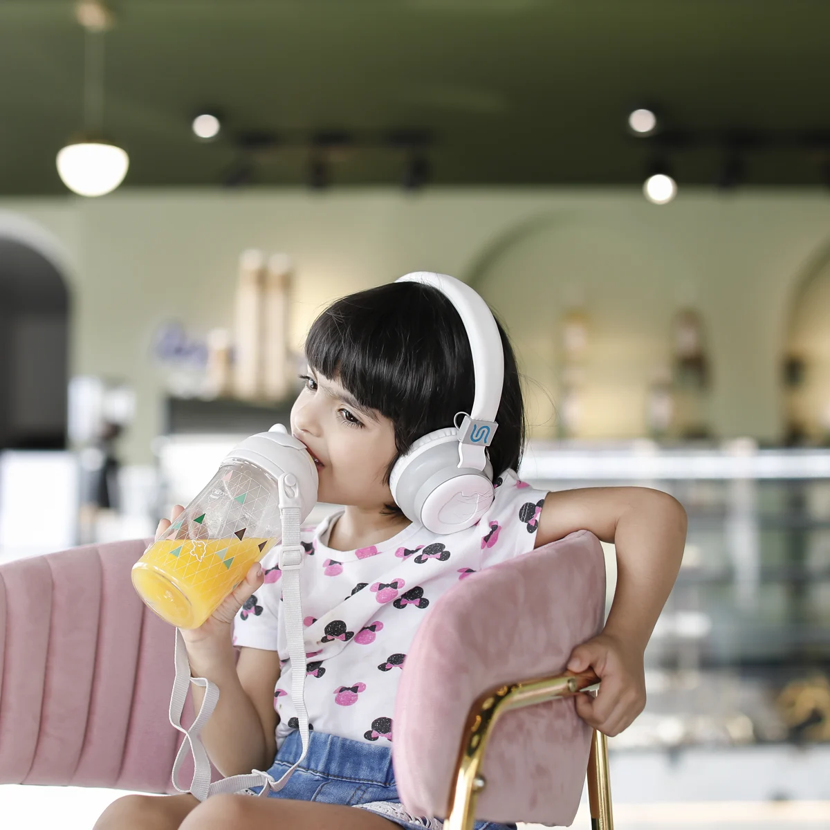 Child wearing headphones in a cafe